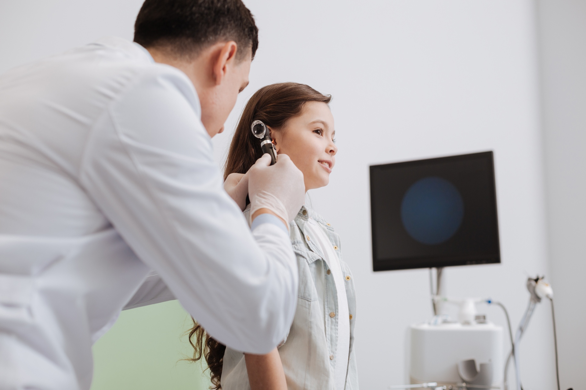 Médico revisando el oído de una paciente